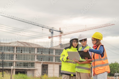 Young and senior Engineers discuss about work of large building underconstruction,Three people working on site of under construction