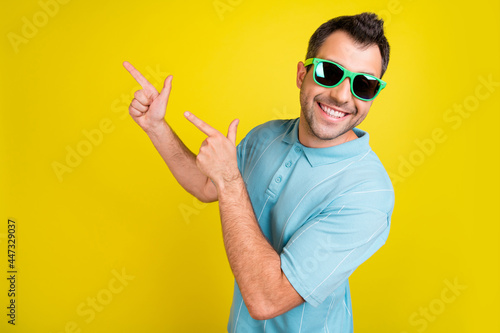 Fényképezés Photo of funky pretty young guy dressed blue t-shirt dark glasses smiling pointi