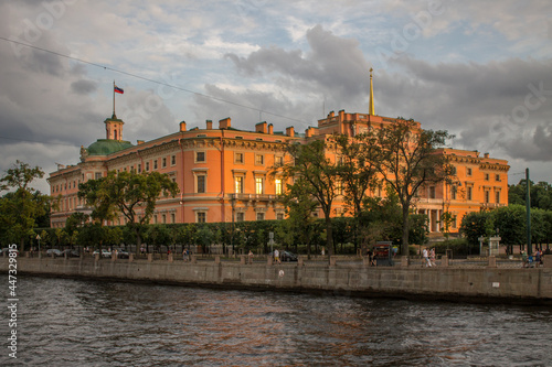 view of the orange Mikhailovsky Castle on the Fontanka River embankment on a summer evening at sunset and a space for copying in Saint-Petersburg photo