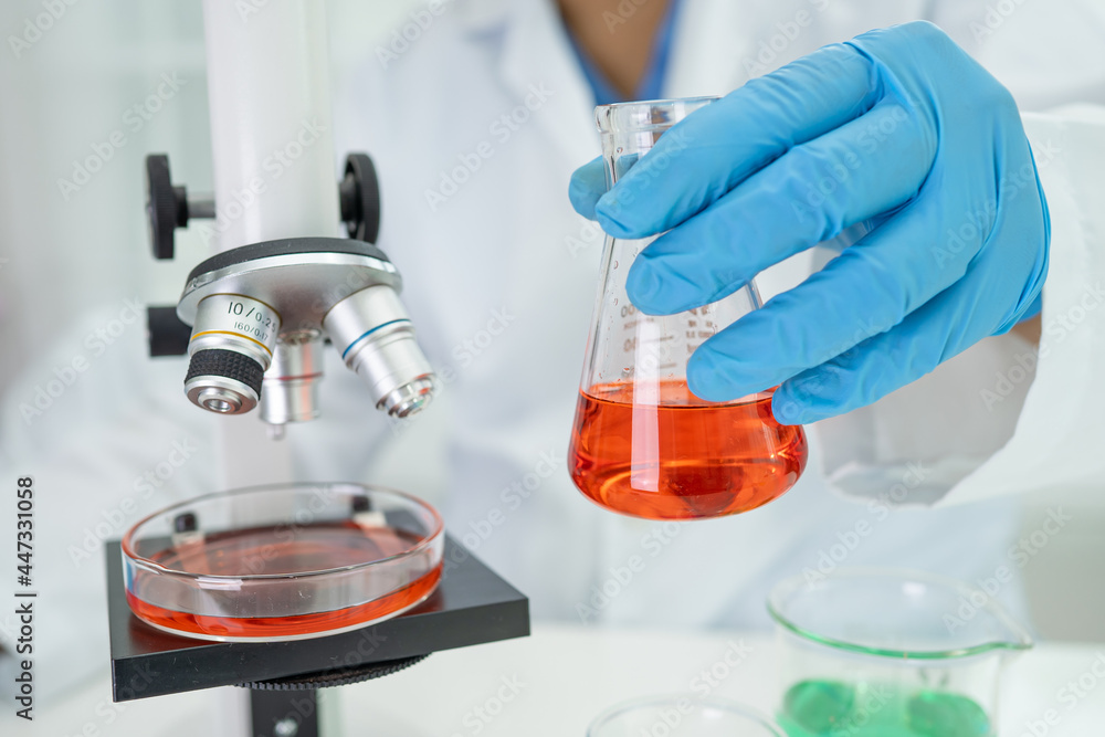 Asian scientist biochemist or microbiologist working research with a microscope in laboratory. Asian scientist biochemist or microbiologist working research with a microscope in laboratory.