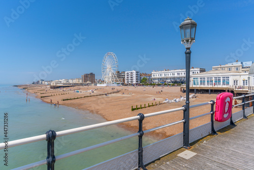 View of beach front houses and ferris wheel from the pier, Worthing, West Sussex, England photo