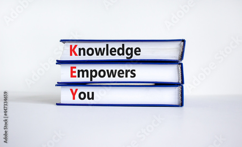 KEY, knowledge empowers you symbol. Books with words 'KEY, knowledge empowers you'. Beautiful white background, copy space. Business, educational and KEY, knowledge empowers you concept.