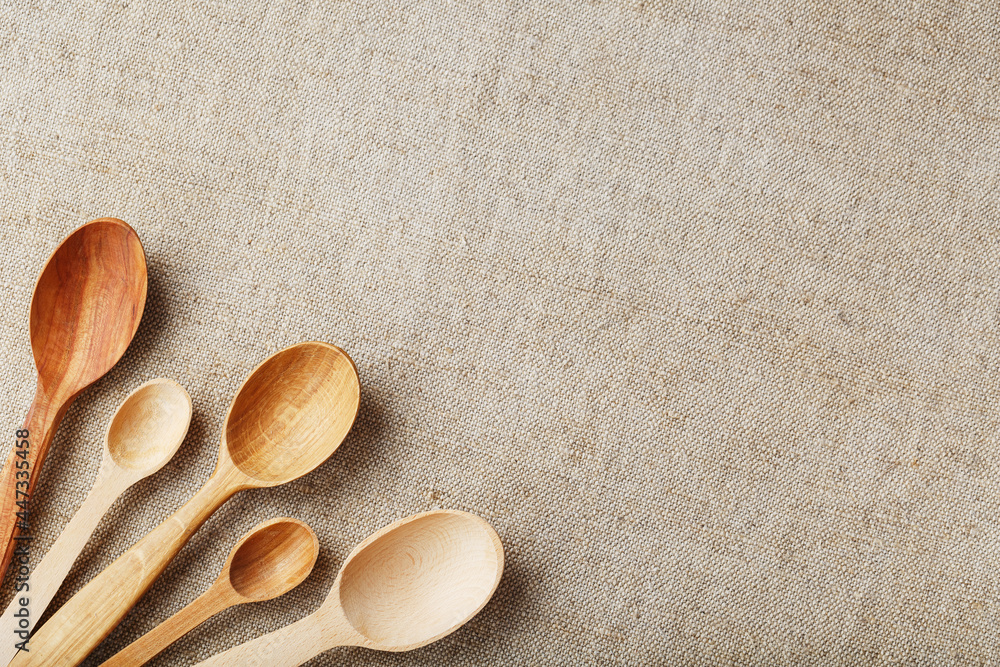 Wooden spoons made of natural wood on burlap fabric as a craft. Wooden spoons made of natural wood on burlap fabric as a craft.