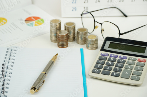 busines, finance, money and bookkeeping concept - calculator, calendar,pen, eyeglasses and thai coins on white background. 