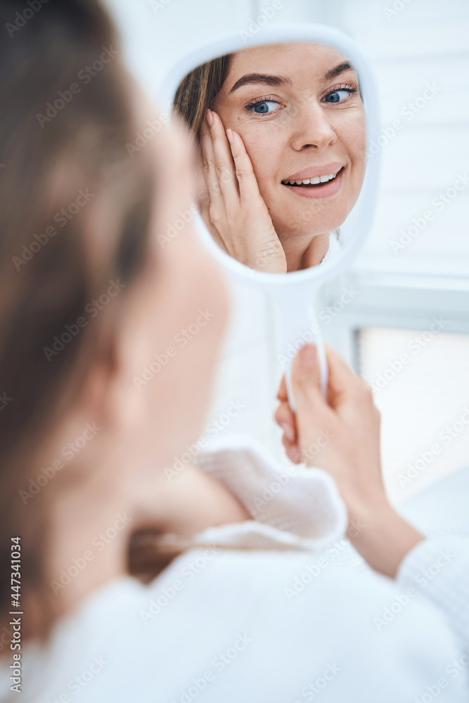 Positive delighted brunette woman enjoying her reflection