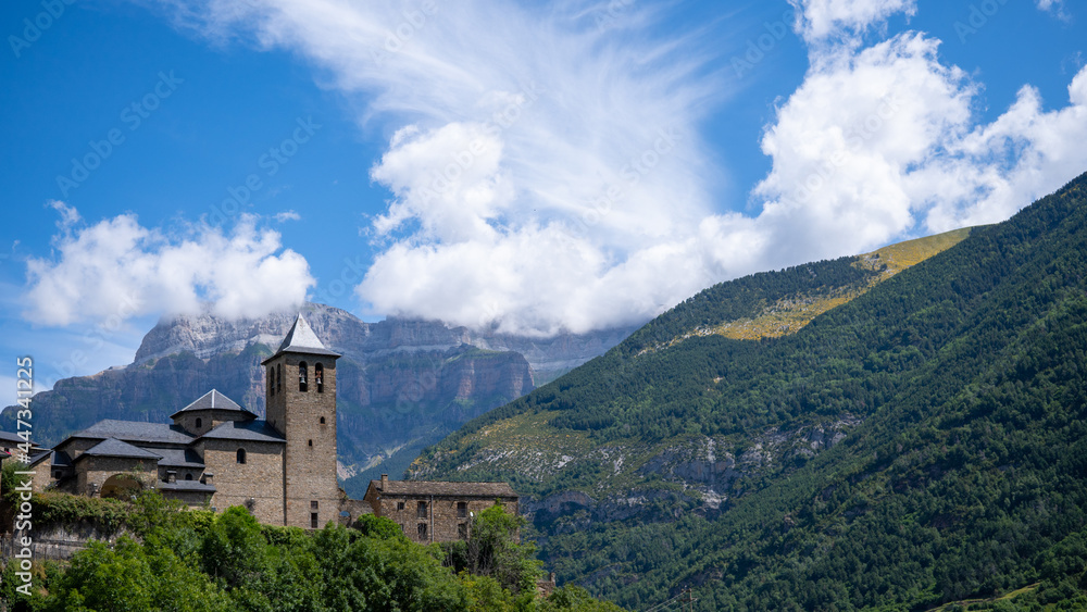 Hermosa vista de la Iglesia de Torla con grandes montañas y verdes colinas en Ordesa, España