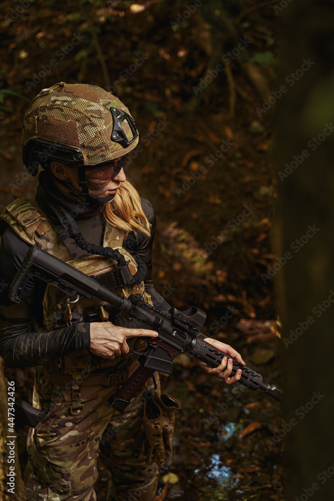 Woman standing in forest and holding hand firearms