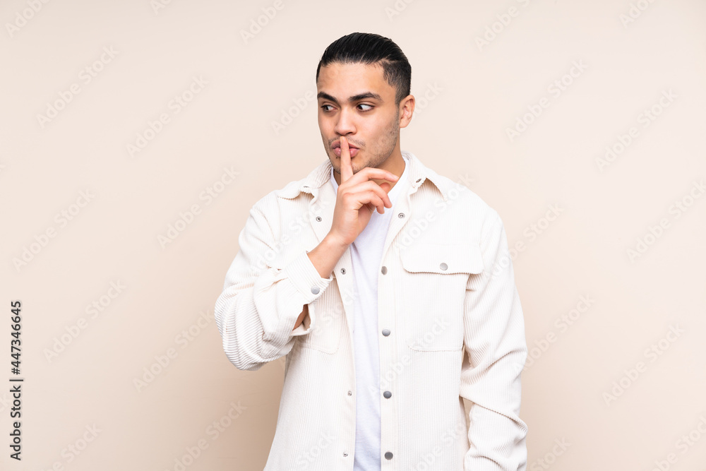 Asian handsome man over isolated background showing a sign of silence gesture putting finger in mouth Asian handsome man over isolated background showing a sign of silence gesture putting finger in mouth