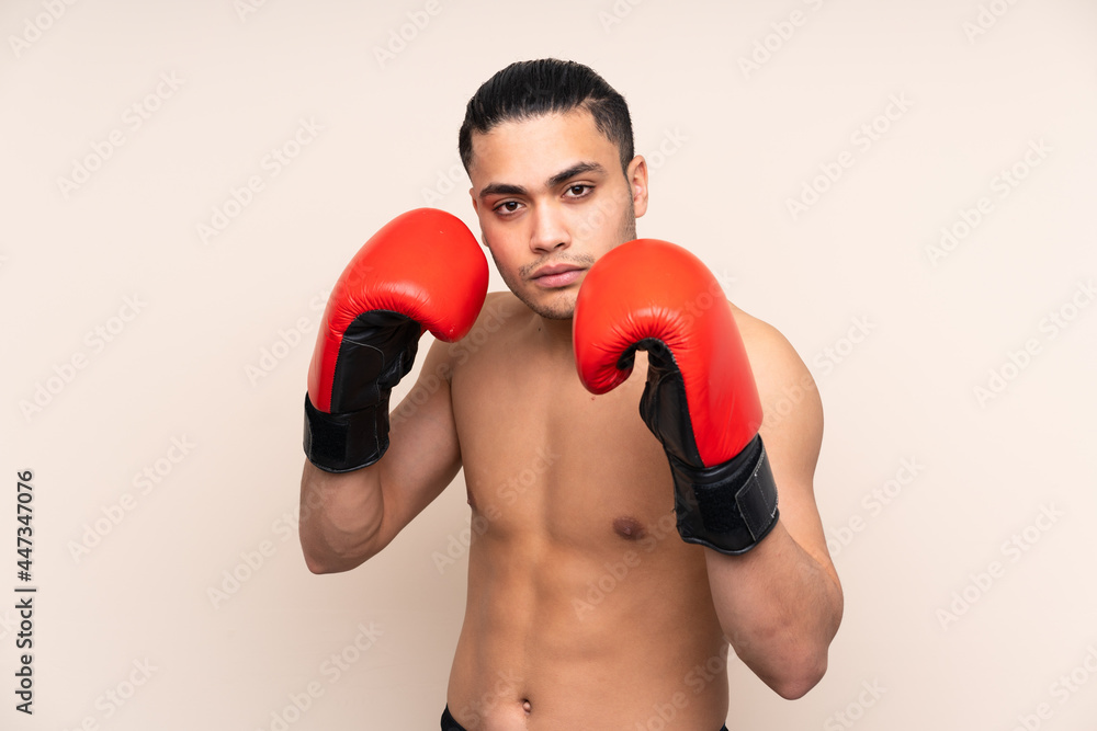 Asian sport man isolated on beige background with boxing gloves
