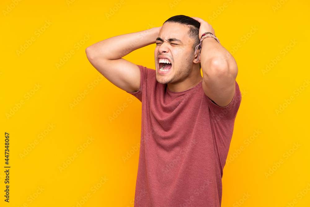 Asian handsome man isolated on yellow background doing surprise gesture while looking to the side Asian handsome man isolated on yellow background doing surprise gesture while looking to the side