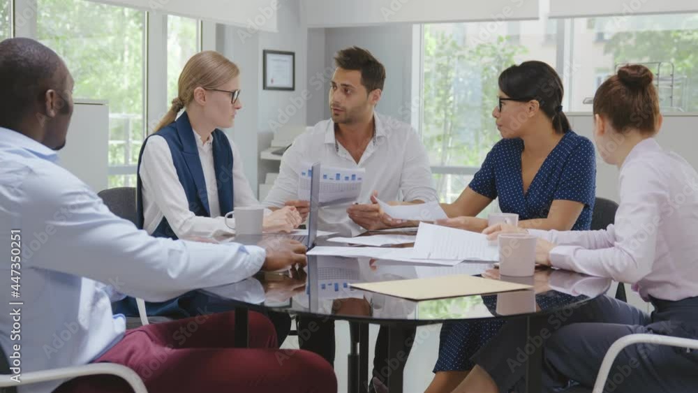 Indian businessman executive in group meeting discussion with employees in modern office