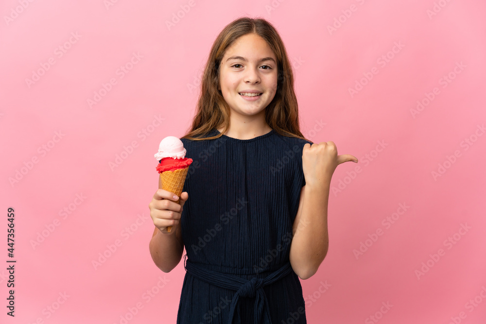 Child with a cornet ice cream over isolated pink background pointing to the side to present a product Child with a cornet ice cream over isolated pink background pointing to the side to present a product