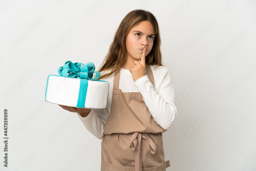 Little girl holding a big cake over isolated white background having doubts while looking up Little girl holding a big cake over isolated white background having doubts while looking up