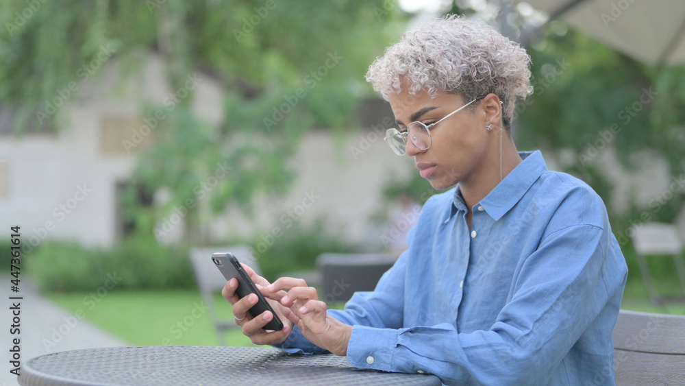 African Woman using Smartphone in Outdoor Cafe African Woman using Smartphone in Outdoor Cafe