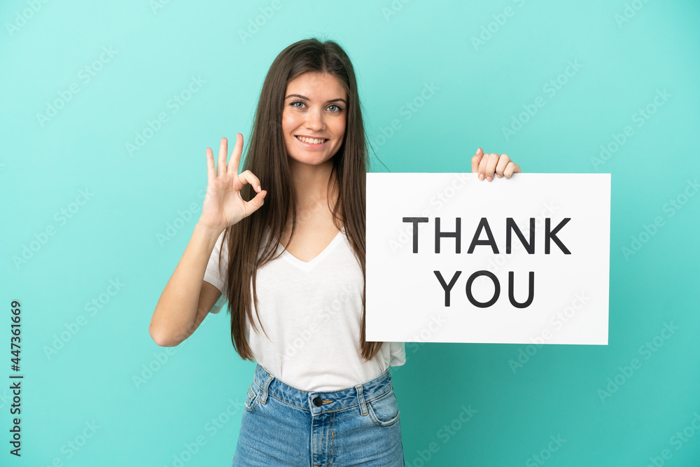 Young caucasian woman isolated on blue background holding a placard with text THANK YOU with ok sign Young caucasian woman isolated on blue background holding a placard with text THANK YOU with ok sign