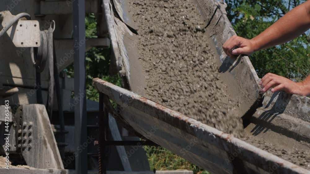 Foreman controls the flow of liquid concrete in the chute Foreman controls the flow of liquid concrete in the chute