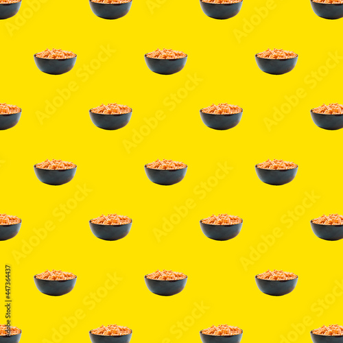 Seamless pattern from Italian Fusili pasta. Isolated cooked Fusili pasta in a black bowl, yellow pop art background