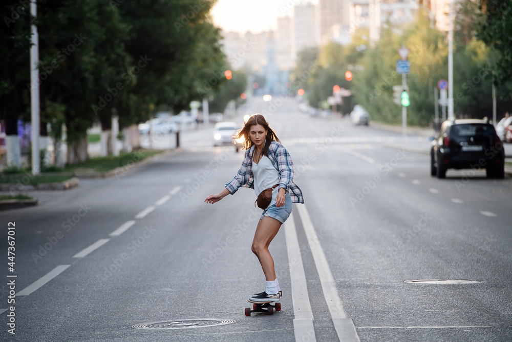 Impressive woman riding on a skateboard on an long beutiful empty city road Impressive woman riding on a skateboard on an long beutiful empty city road