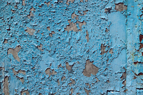 Grungy cracked weathered wall. Blue paint peeling off rusted metal sheet. Rustic textured background
