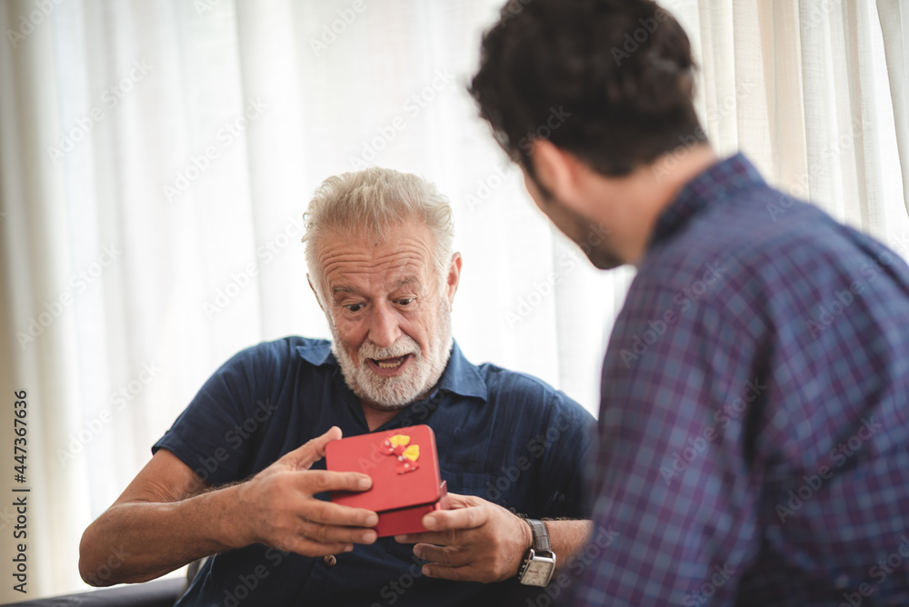 caucasian man surprise him adult father with giving gift box to celebration at home, family present to happy together lifestyle with love, people having fun and smiling in holiday caucasian man surprise him adult father with giving gift box to celebration at home, family present to happy together lifestyle with love, people having fun and smiling in holiday