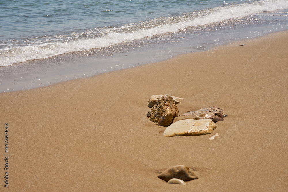 Stones on tropical sandy beach with blurred waves on the background. Stones on tropical sandy beach with blurred waves on the background.