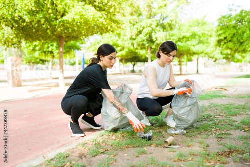Attractive friends helping cleaning the park