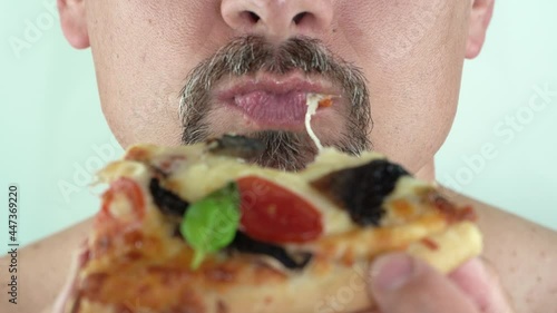 Middle aged man with beard holding in hands eating vegetarian pizza, 4K close up