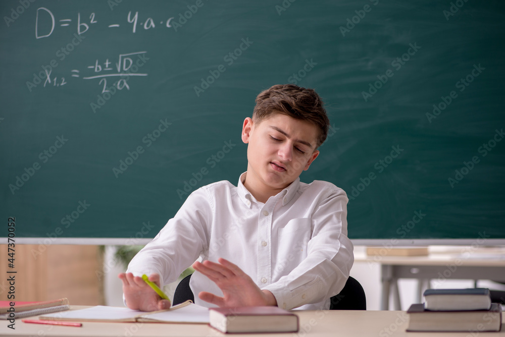 Schoolboy studying math in front of blackboard Schoolboy studying math in front of blackboard