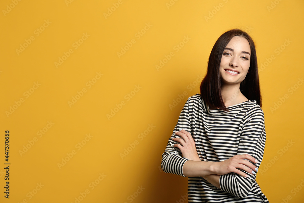 Portrait of pretty young woman with gorgeous chestnut hair and charming smile on yellow background, space for text Portrait of pretty young woman with gorgeous chestnut hair and charming smile on yellow background, space for text