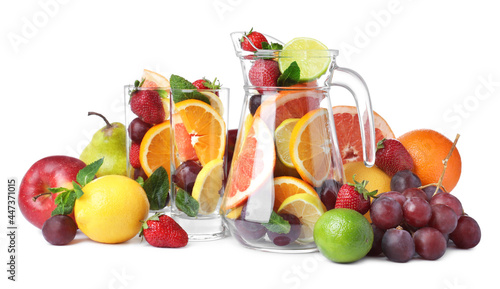 Jug and glasses with different fruits on white background