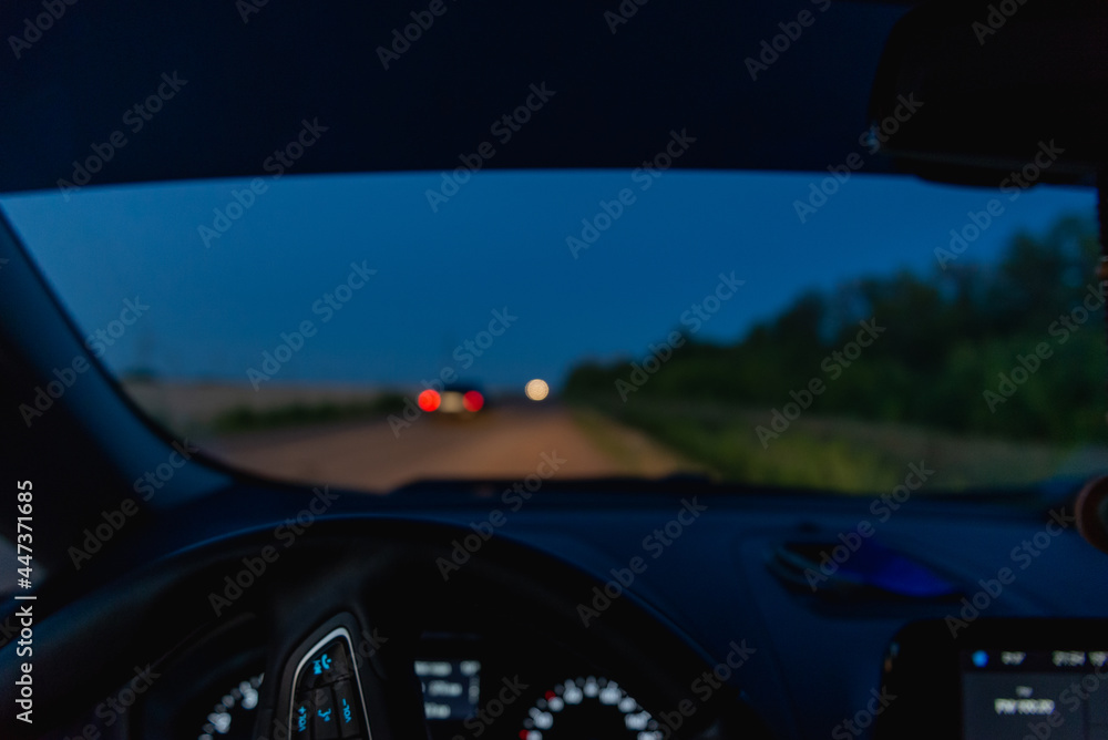 Night road from the car from the driver's seat. The lights of the cars are visible.