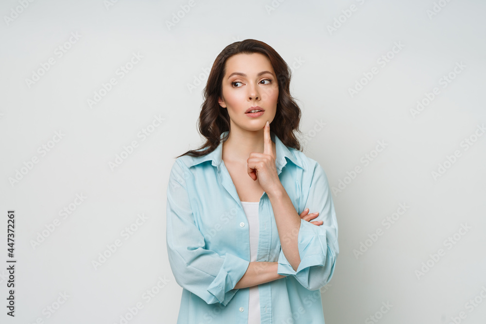 A confused woman stands uncertainly, shrugs her shoulders, can't give an answer to a difficult question, has a confused expression on her face. A confused woman stands uncertainly, shrugs her shoulders, can't give an answer to a difficult question, has a confused expression on her face.
