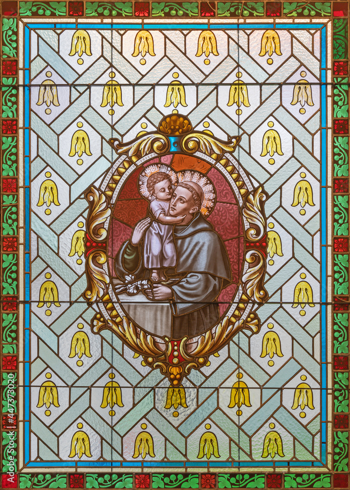 VIENNA, AUSTIRA - JUNI 17, 2021: The  St. Anthony of Padua on the stained glass of church  Alserkirche  by Franz Gotzer from 20. cent.