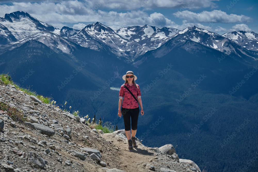 Middle age woman walking in mountains in summer. Walking trail from Whistler gondola. Whislter Blackcomb Ski resort. British Columbia. Canada 