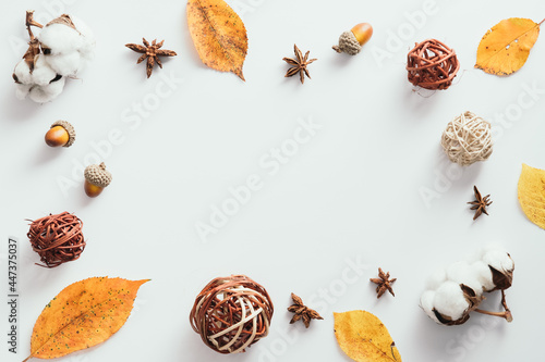 Autumn flatlay composition. Frame made of dried leaves, decor, cotton on white background