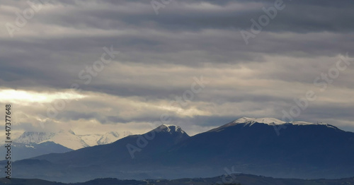 Nuvole grigie sopra le montagne innevate