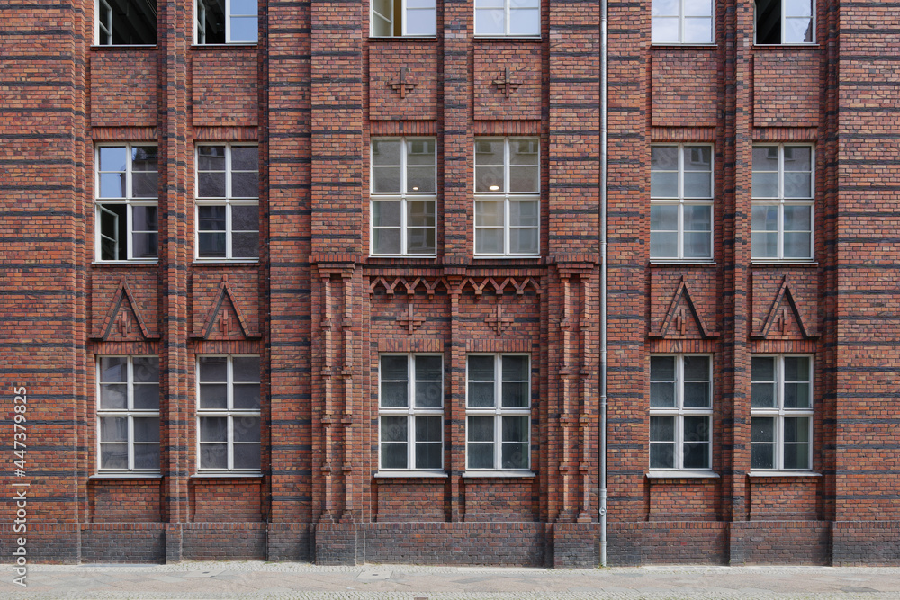Exterior front street view of rough vintage red brick classical facade of typical old building in Berlin, Germany.