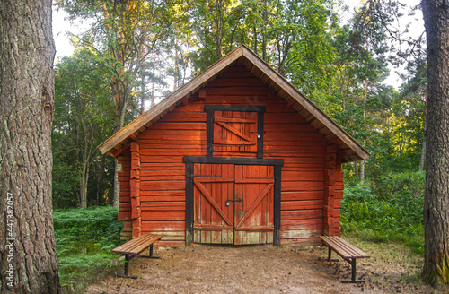 Old wooden red storage cabin in a forest  