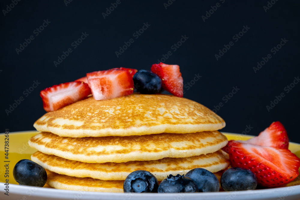 Hot pancake with berries in black background