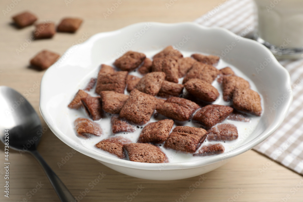 Bowl with tasty corn pads and milk on wooden table, closeup Bowl with tasty corn pads and milk on wooden table, closeup