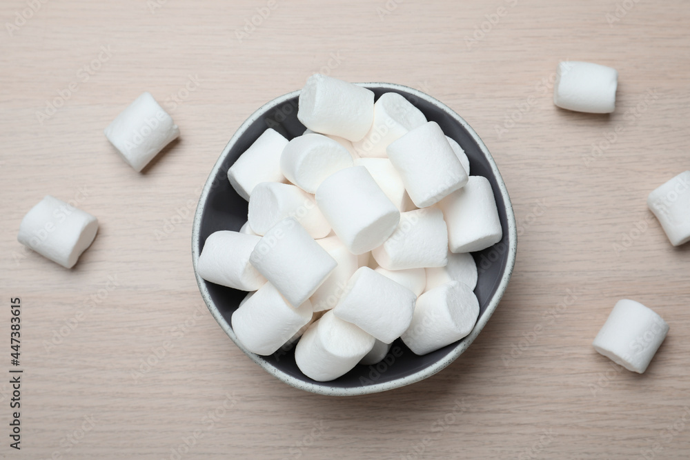 Delicious puffy marshmallows on wooden table, flat lay Delicious puffy marshmallows on wooden table, flat lay