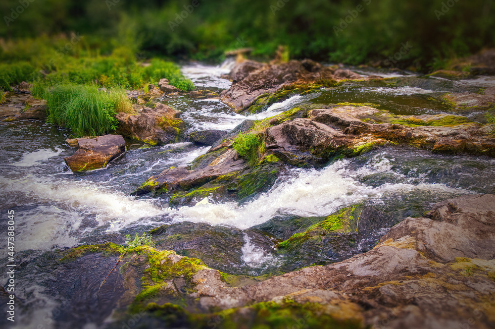 Strong water currents and lots of greenery in a natural rapids with stopped motion in Myllykoski rapids, Finland, Nurmijärvi Strong water currents and lots of greenery in a natural rapids with stopped motion in Myllykoski rapids, Finland, Nurmijärvi