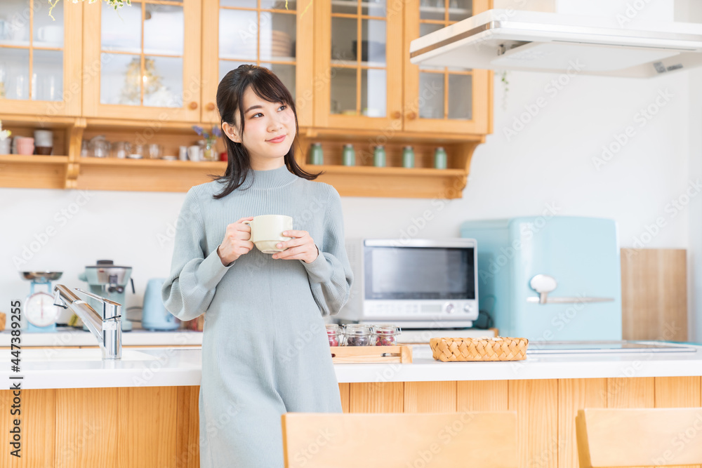 部屋で飲み物を飲む女性 部屋で飲み物を飲む女性