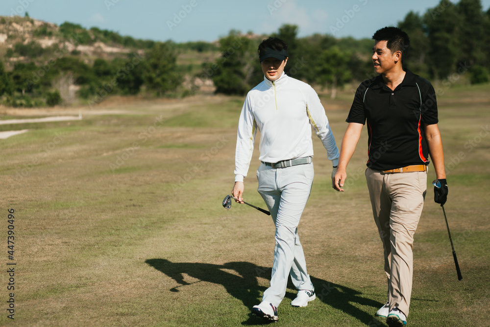 Obraz premium Golfers happily walking with golf clubs on green grass in the morning