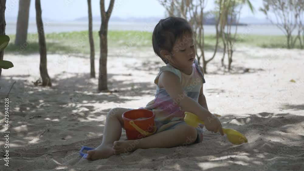 Happy little child girl playing with sand at resort tropical beach on holiday summer travel Happy little child girl playing with sand at resort tropical beach on holiday summer travel