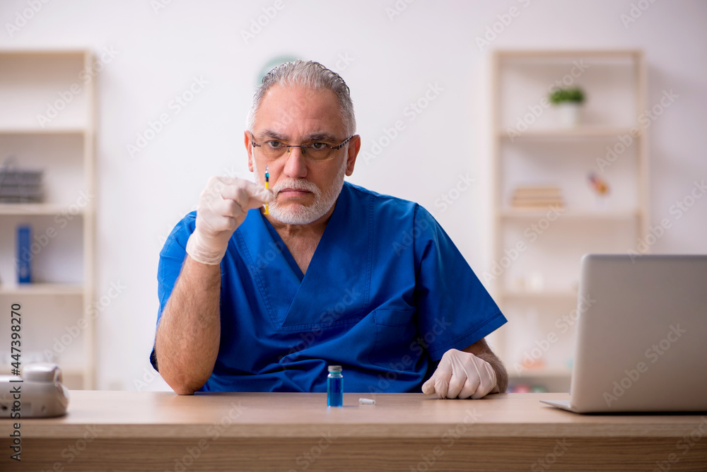 Fototapeta premium Old male doctor in vaccination concept