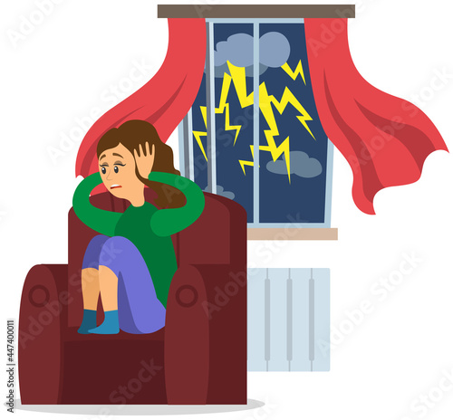 Stressed girl covers ears with hands sitting at home while it rains outside window with thunderstorm. Woman is afraid of loud sounds, fear lightning. Acoustic phobia, female with scared face emotion