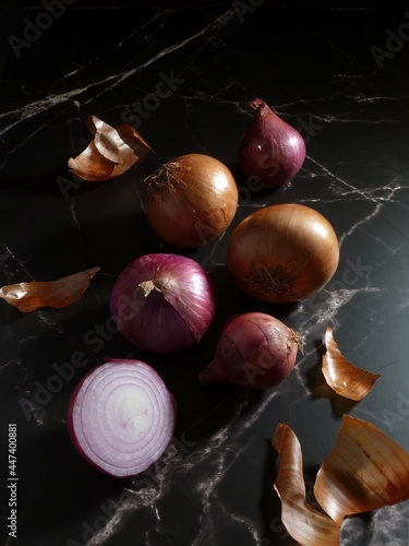 Yellow and red onions dispayed on a marble table in the morning sunshine