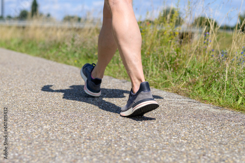 Legs of an athletic overweight woman in sportswear walking