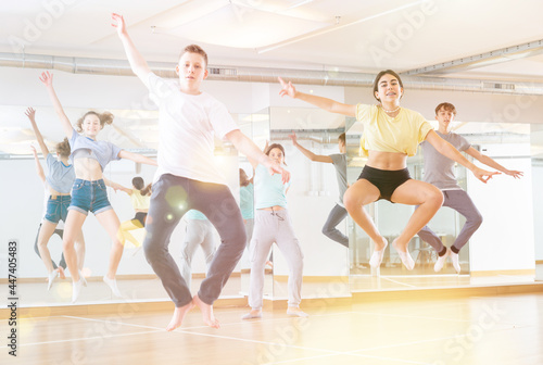 Group of young dancers jumping together in dance class